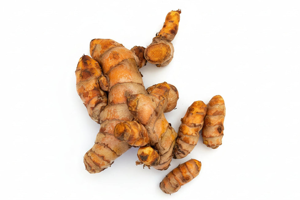 Turmeric roots on a light wooden surface
