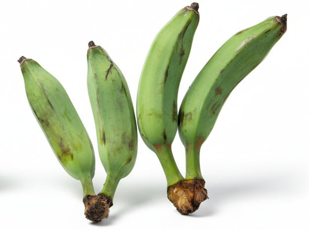 Three green bananas on a light wooden floor