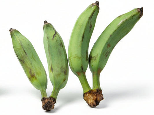 Three green bananas on a light wooden floor